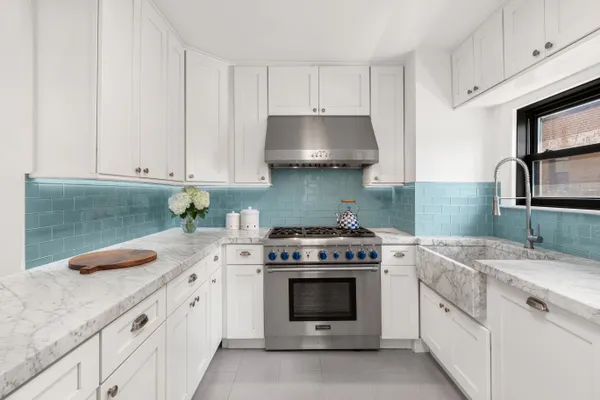 a kitchen with granite countertop a sink stove and cabinets