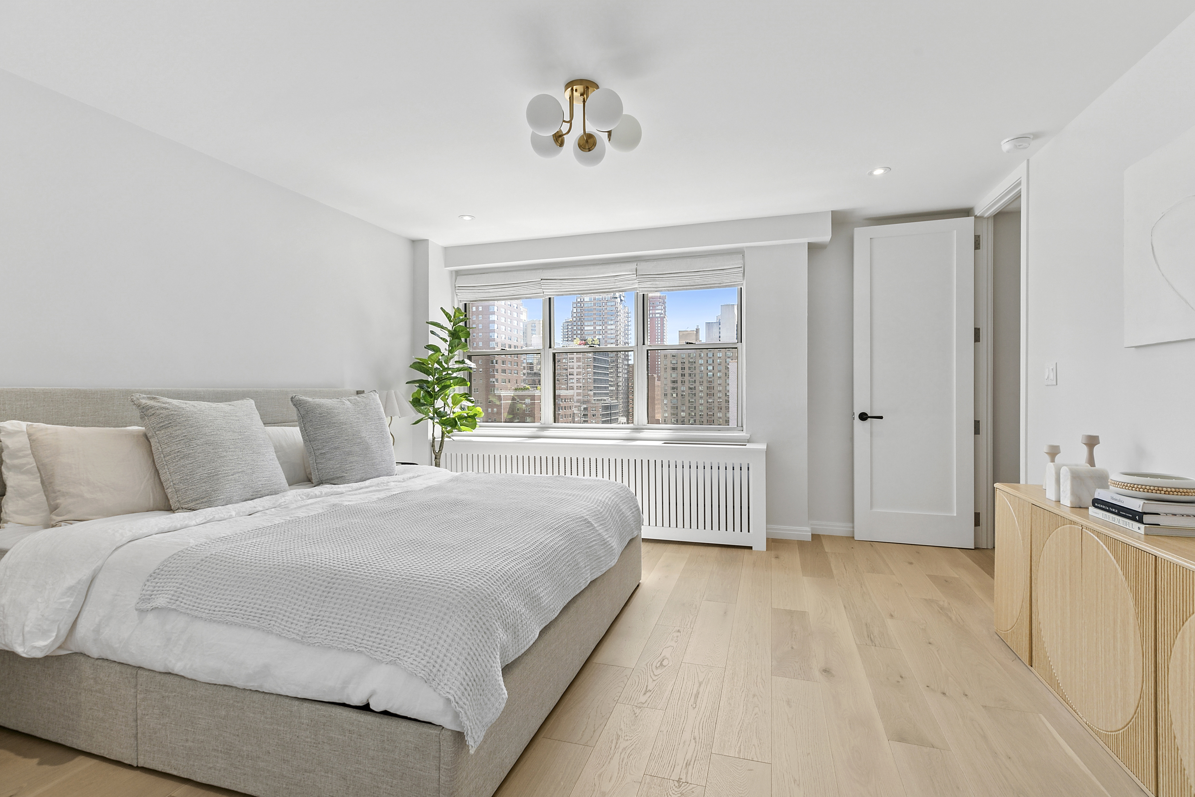 300 East 71st Street, Unit 17DEF Manhattan, NY 10021 - Photo 5 of 16 a bedroom with a large bed and a large window