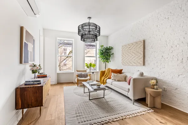 a living room with furniture chandelier and a window