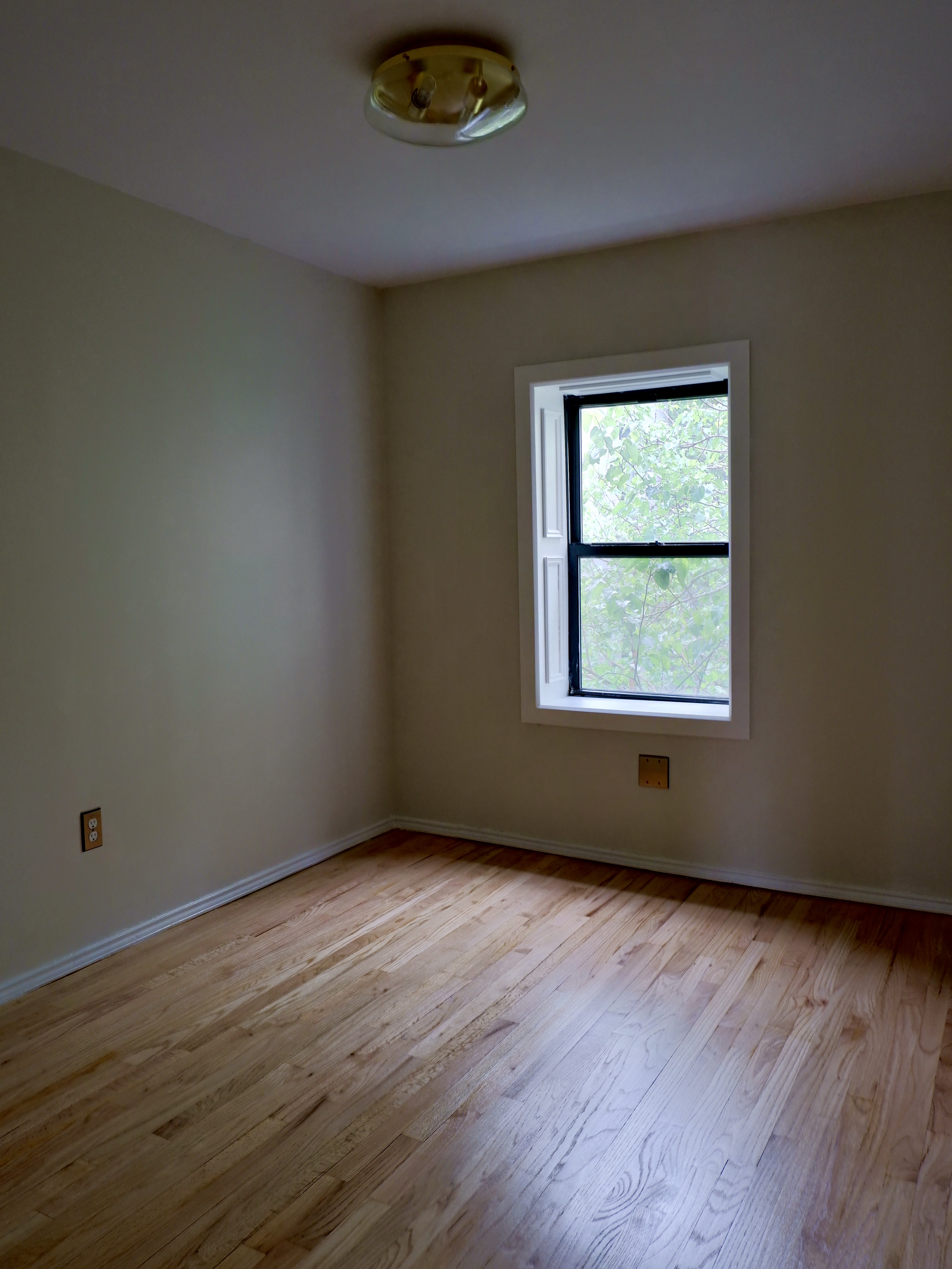 132 Decatur Street, Unit 3 Brooklyn, NY 11216 - Photo 15 of 17 an empty room with wooden floor and windows