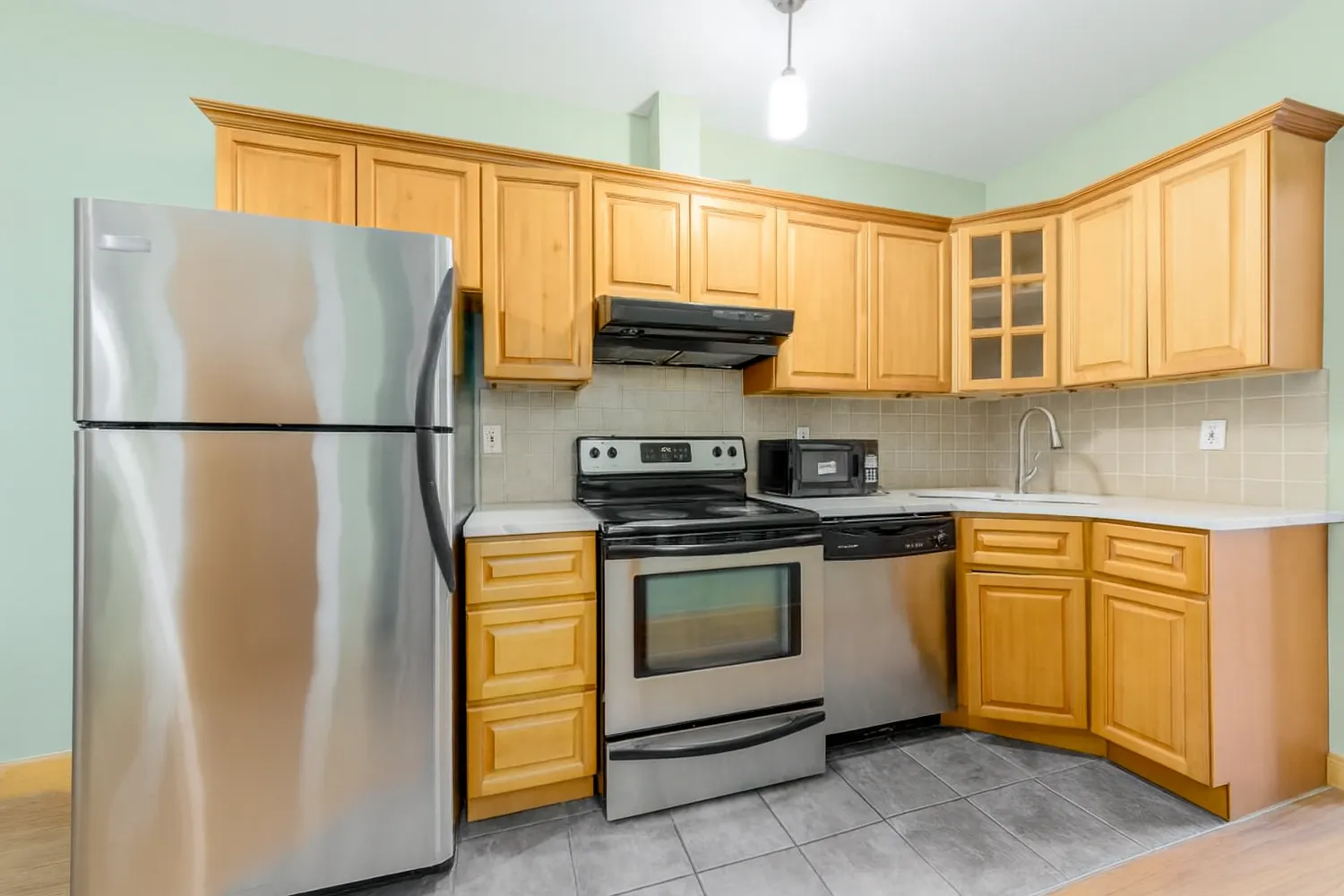 a kitchen with stainless steel appliances granite countertop a refrigerator sink and stove