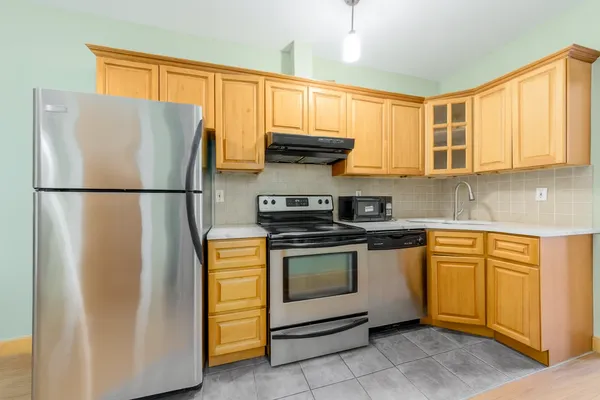 a kitchen with stainless steel appliances granite countertop a refrigerator sink and stove