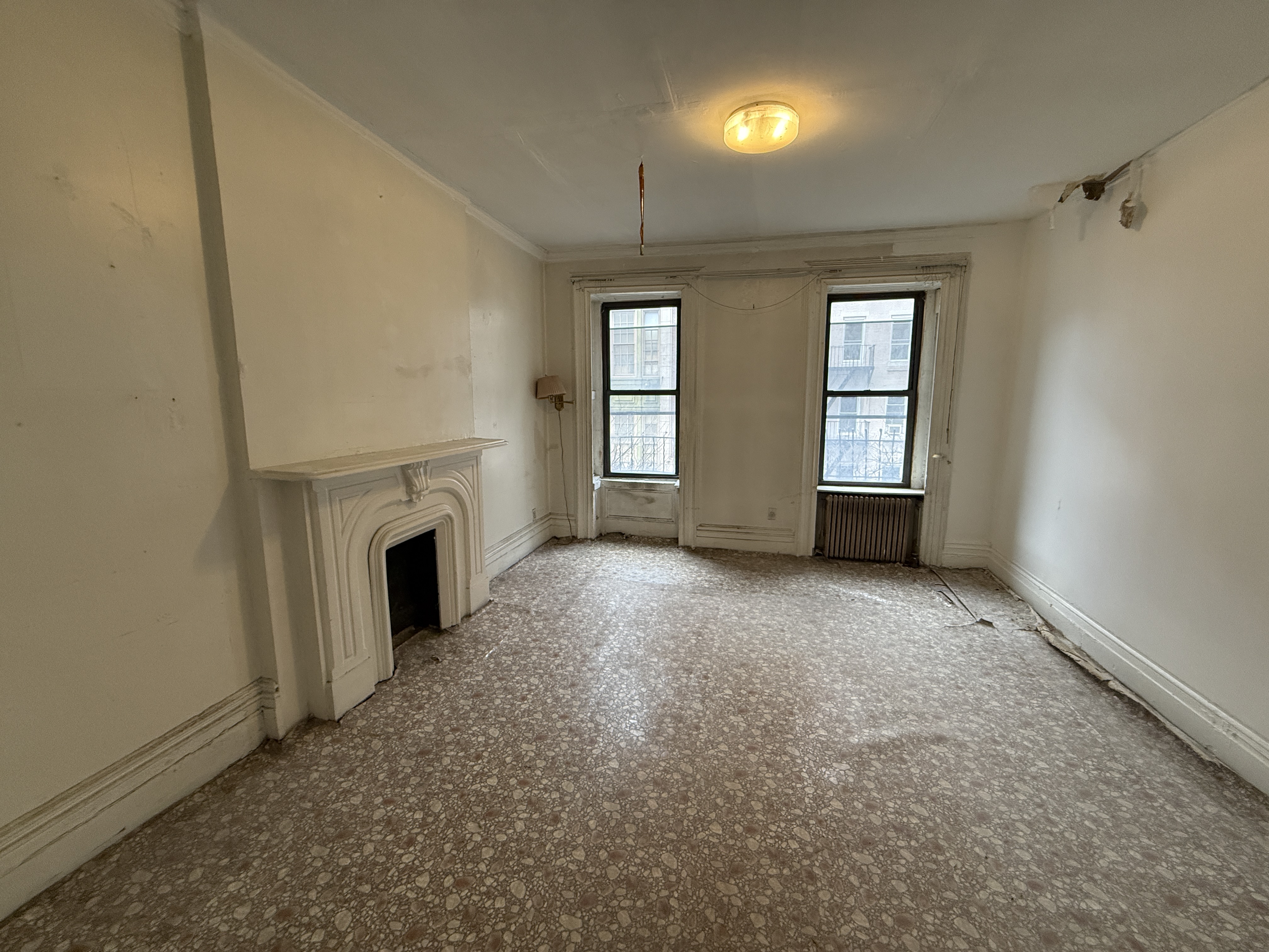 320 West 47th Street, Unit 4W Manhattan, NY 10036 - Photo 9 of 11 an empty room with windows and fireplace