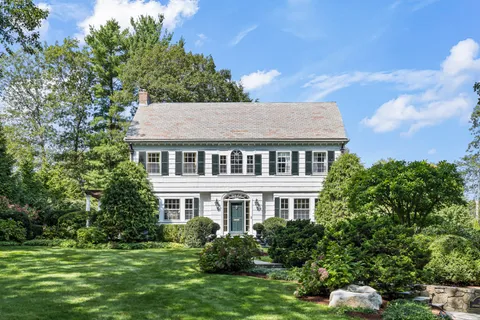 a aerial view of a house next to a big yard and large trees