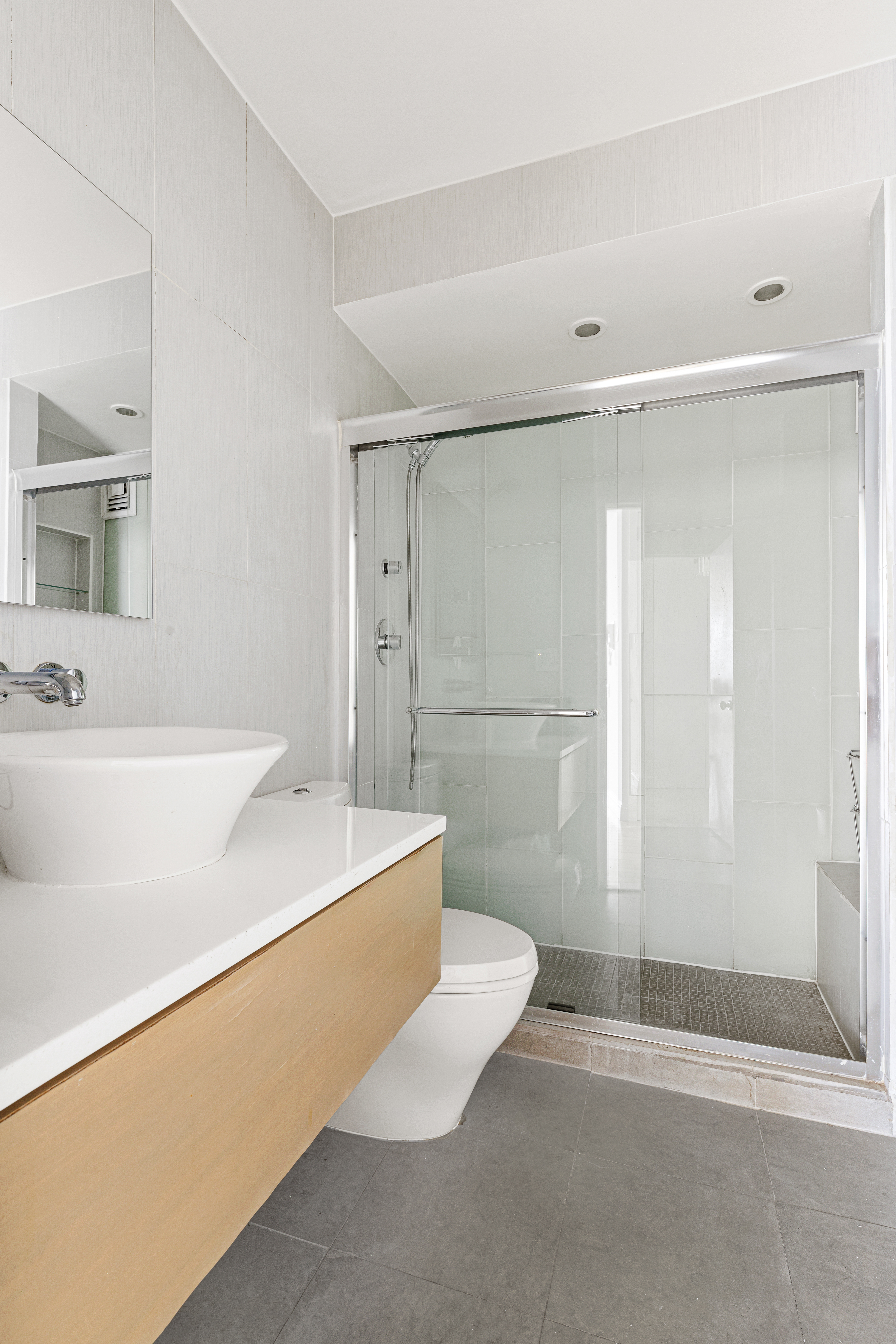 140 Charles Street, Unit 7A Manhattan, NY 10014 - Photo 5 of 8 a bathroom with a sink a toilet a mirror and shower