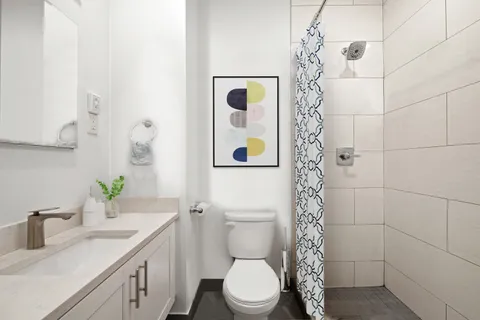 a bathroom with a sink a toilet and shower