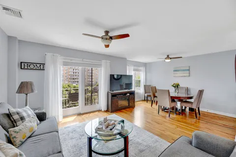 a living room with furniture and a flat screen tv with kitchen view