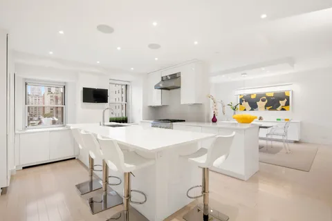 a kitchen with stainless steel appliances kitchen island granite countertop a sink and chairs