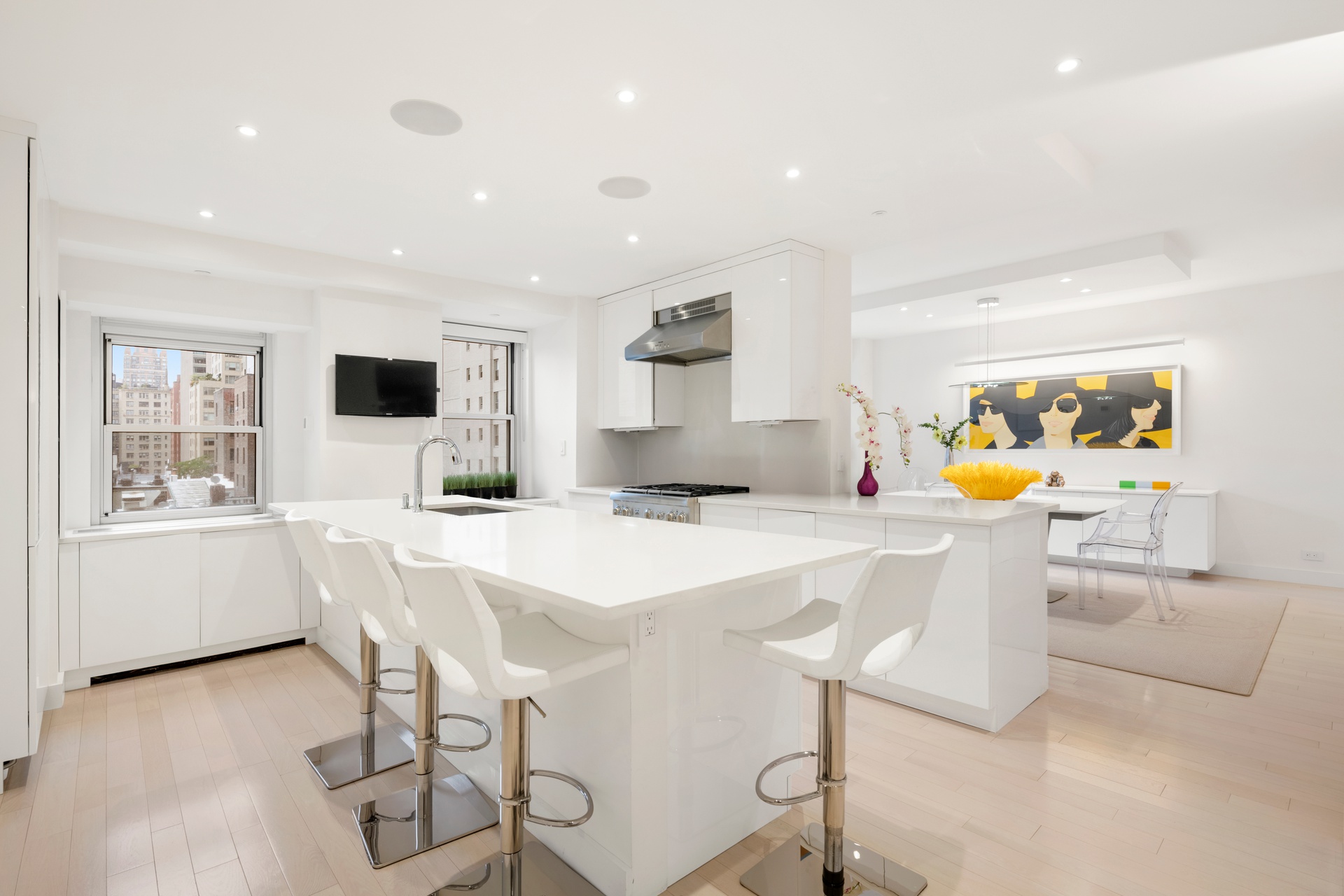 150 East 69th Street, Unit 7K Manhattan, NY 10021 - Photo 4 of 22 a kitchen with stainless steel appliances kitchen island granite countertop a sink and chairs