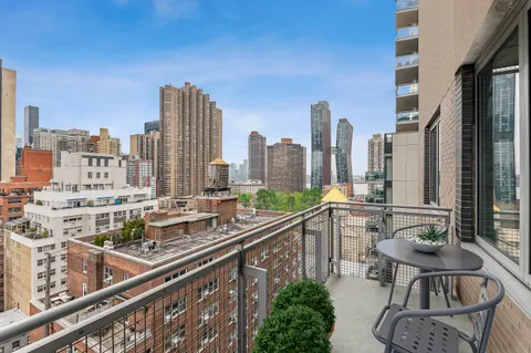 a view of balcony with chairs and iron fence