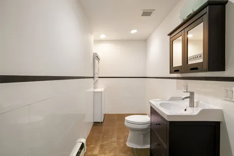 a bathroom with a sink mirror and toilet