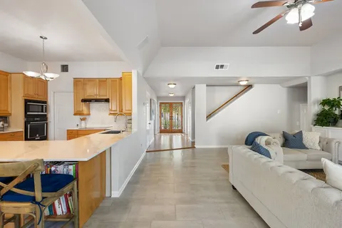 a large living room with stainless steel appliances kitchen island granite countertop furniture and a fireplace