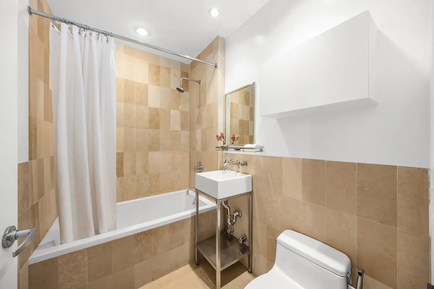 a bathroom with a sink a toilet a mirror and shower