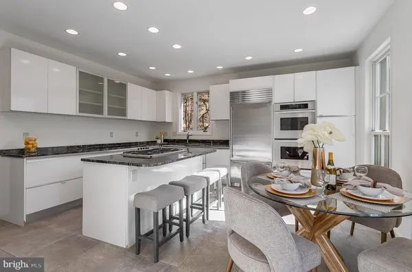 a kitchen with granite countertop a sink stove and refrigerator
