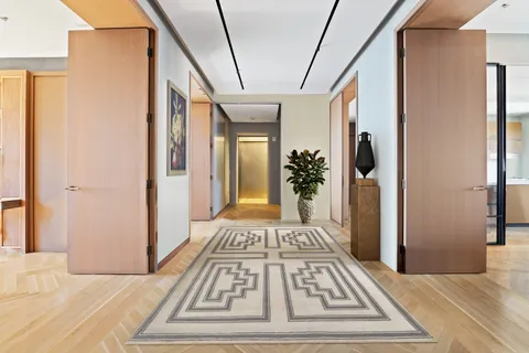 a view of a hallway and a livingroom with furniture