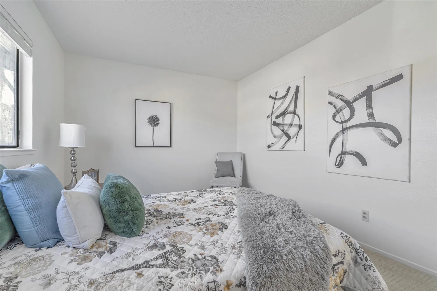 a bedroom with a bed lamps and a window