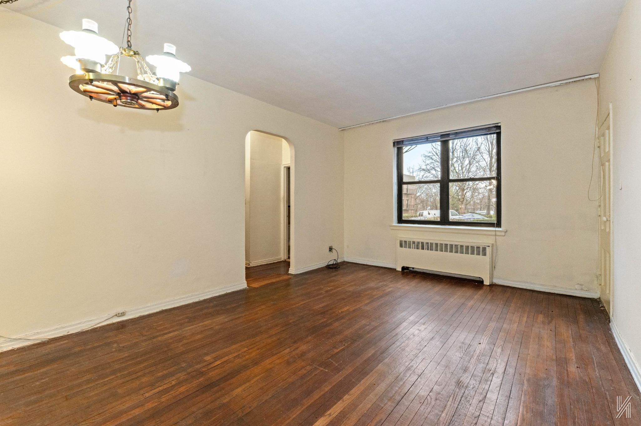 22-60 79th Street, Unit 1A Queens, NY 11370 - Photo 2 of 17 a view of an empty room with wooden floor and a window