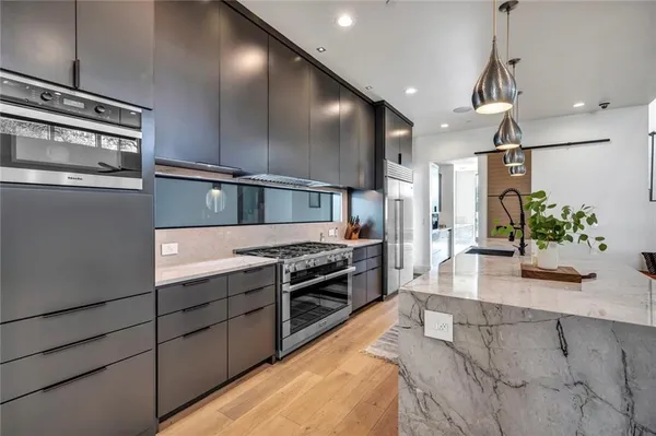 a large kitchen with stainless steel appliances a large counter top