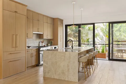 a kitchen with stainless steel appliances granite countertop a stove a refrigerator a kitchen island a stove and a cabinets with wooden floor