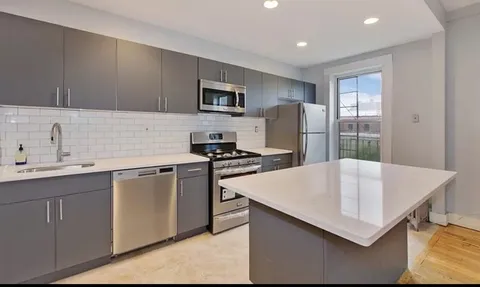 a kitchen with stainless steel appliances a microwave sink and refrigerator
