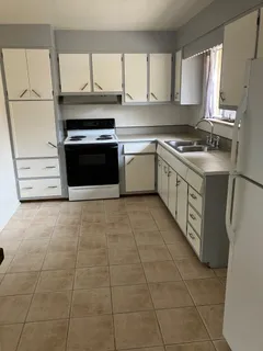 a kitchen with a stove top oven and cabinets