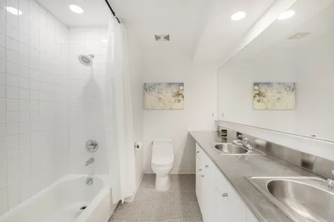 a spacious bathroom with a sink a toilet and a bathtub