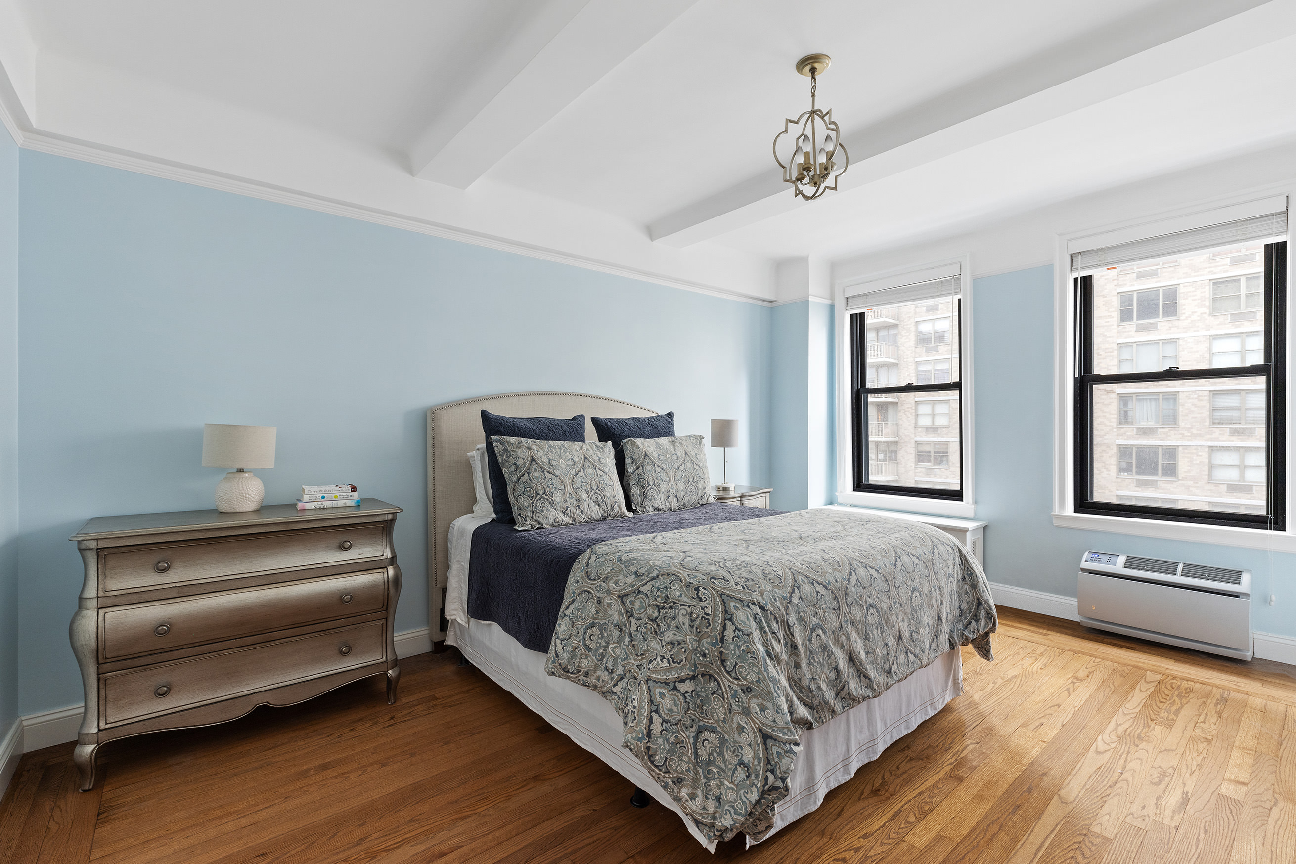 308 East 79th Street, Unit 9E Manhattan, NY 10075 - Photo 5 of 7 a bedroom with a bed and a large window with wooden floor