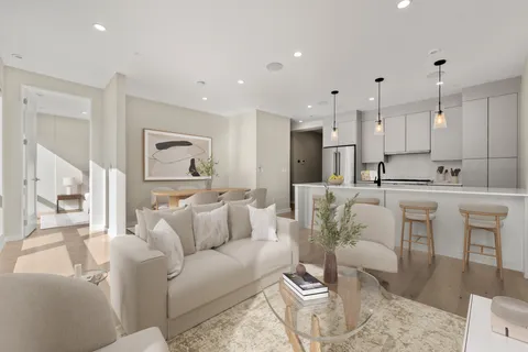 a living room with furniture white walls and a view of kitchen
