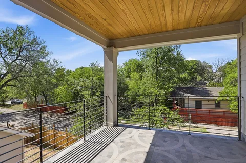 a balcony with view of trees in front of it