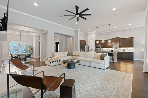 a living room with furniture kitchen view and a chandelier