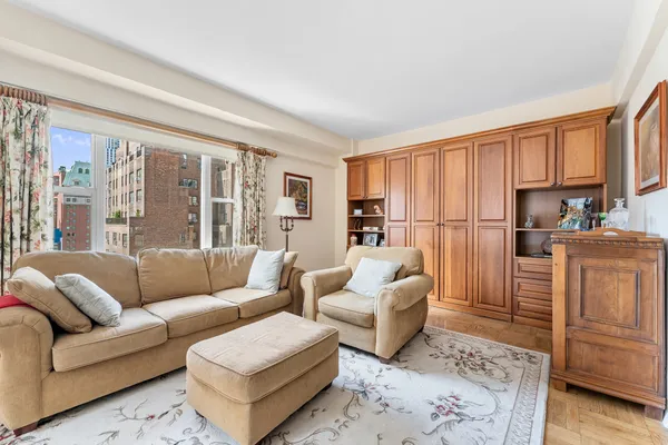 a living room with furniture and a refrigerator