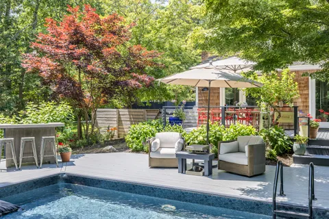 a patio with a table and chairs under an umbrella