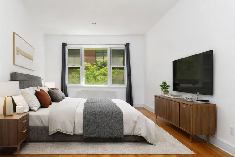 41-26 27th Street, Unit 6G Queens, NY 11101 - Photo 5 of 7 a bedroom with a large bed and a flat screen tv