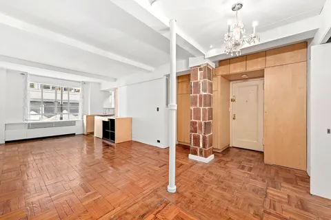 a view of a livingroom with a fireplace cabinet and window
