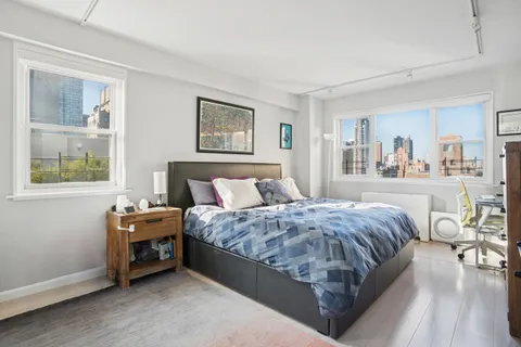 a bedroom with bed and wooden floor