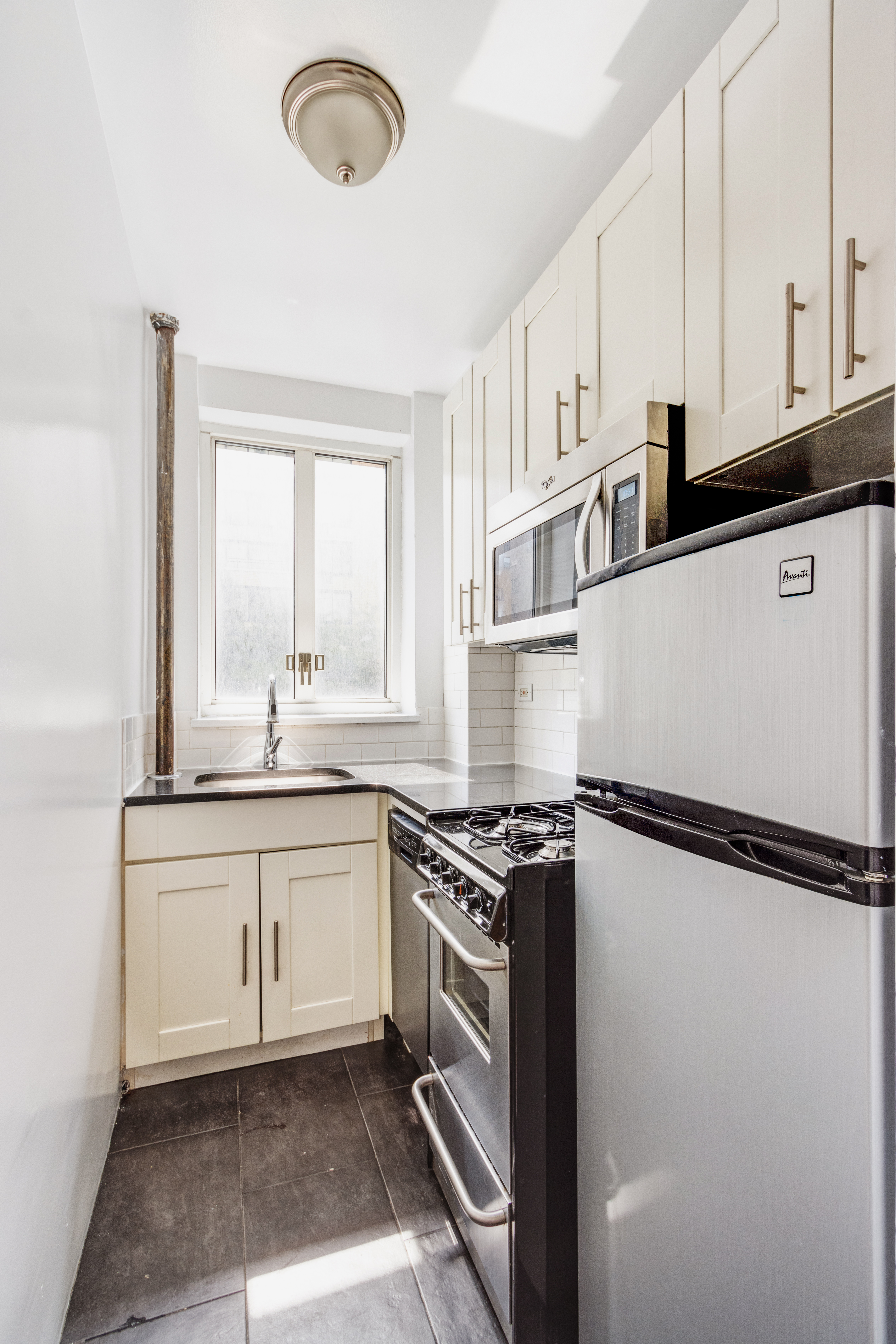 200 West 20th Street, Unit 206 Manhattan, NY 10011 - Photo 3 of 8 a kitchen with granite countertop a sink stainless steel appliances and cabinets