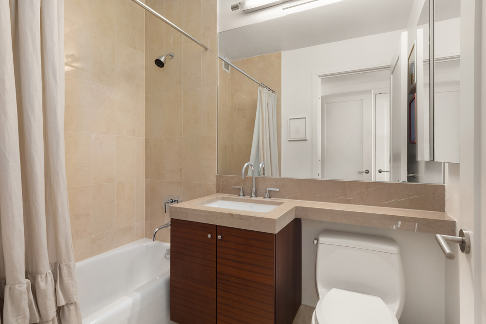 30 West Street, Unit 19F Manhattan, NY 10004 - Photo 9 of 12 a bathroom with a sink and a mirror