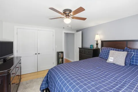a bedroom with a bed and a flat tv screen on dresser