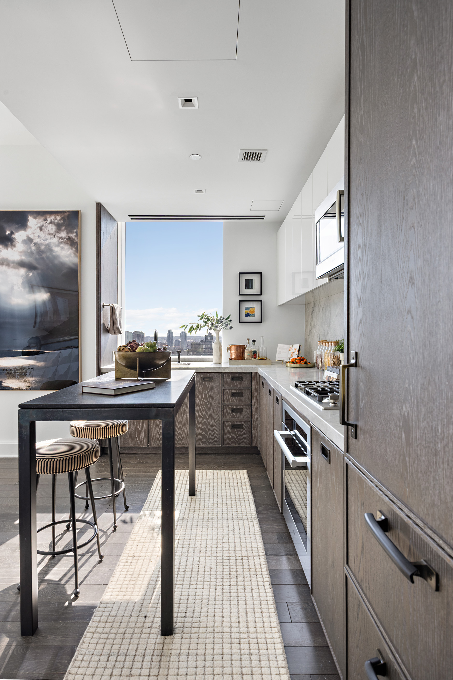 45 East 22nd Street, Unit 32B Manhattan, NY 10010 - Photo 6 of 36 a kitchen with stainless steel appliances a table chairs and a refrigerator
