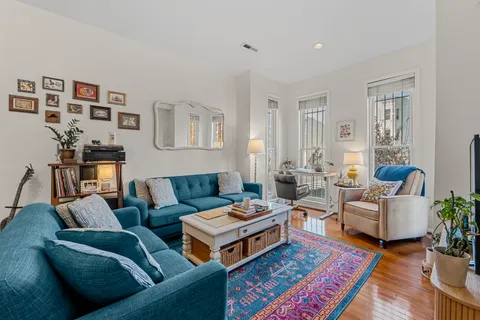a living room with furniture and a wooden floor
