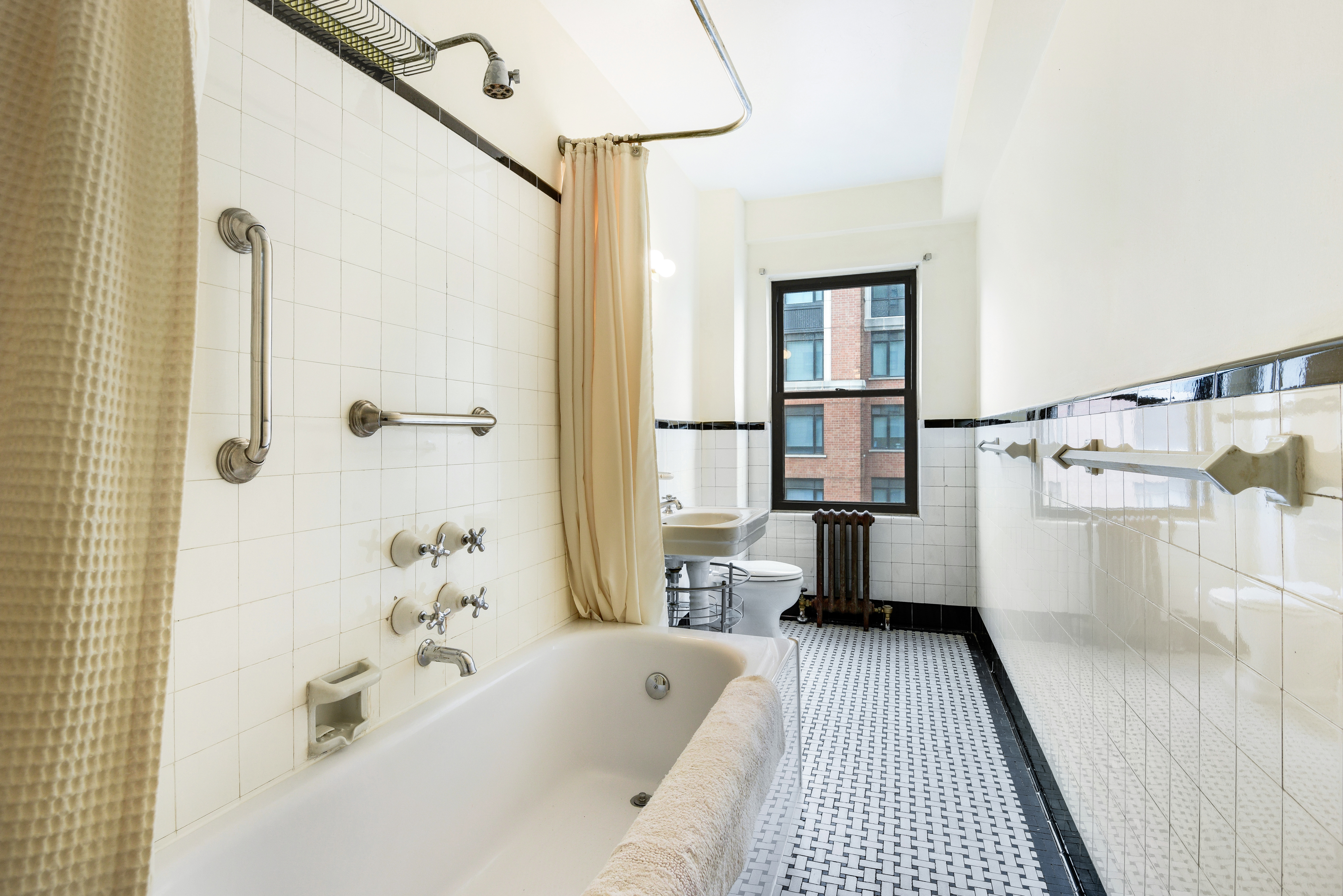 49 East 96th Street, Unit 8/9E Manhattan, NY 10128 - Photo 13 of 17 a bathroom with a tub sink and view of bathroom