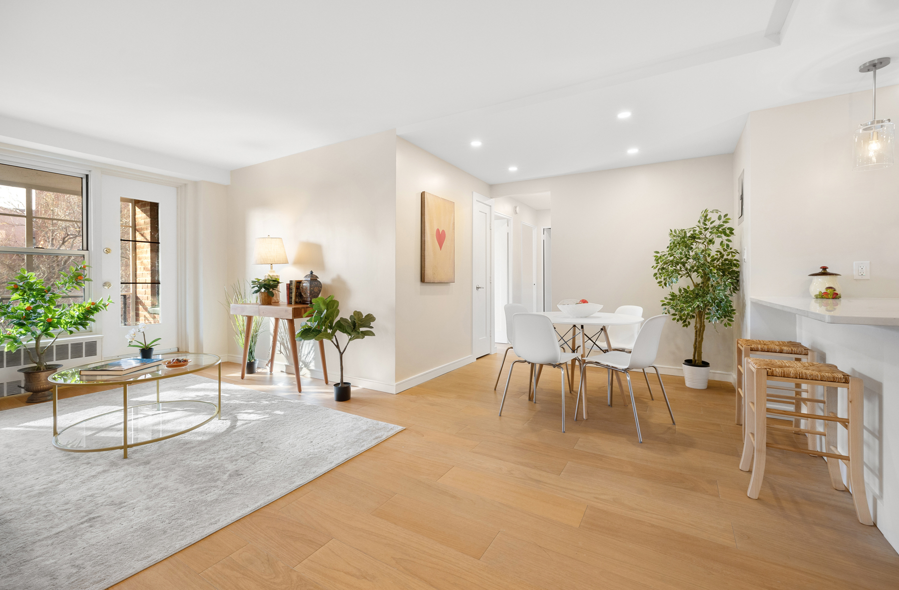 35-51 85th Street, Unit 5E Queens, NY 11372 - Photo 5 of 16 a living room with furniture a potted plant and a large window