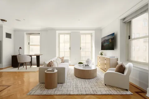 a living room with furniture a flat screen tv and a window