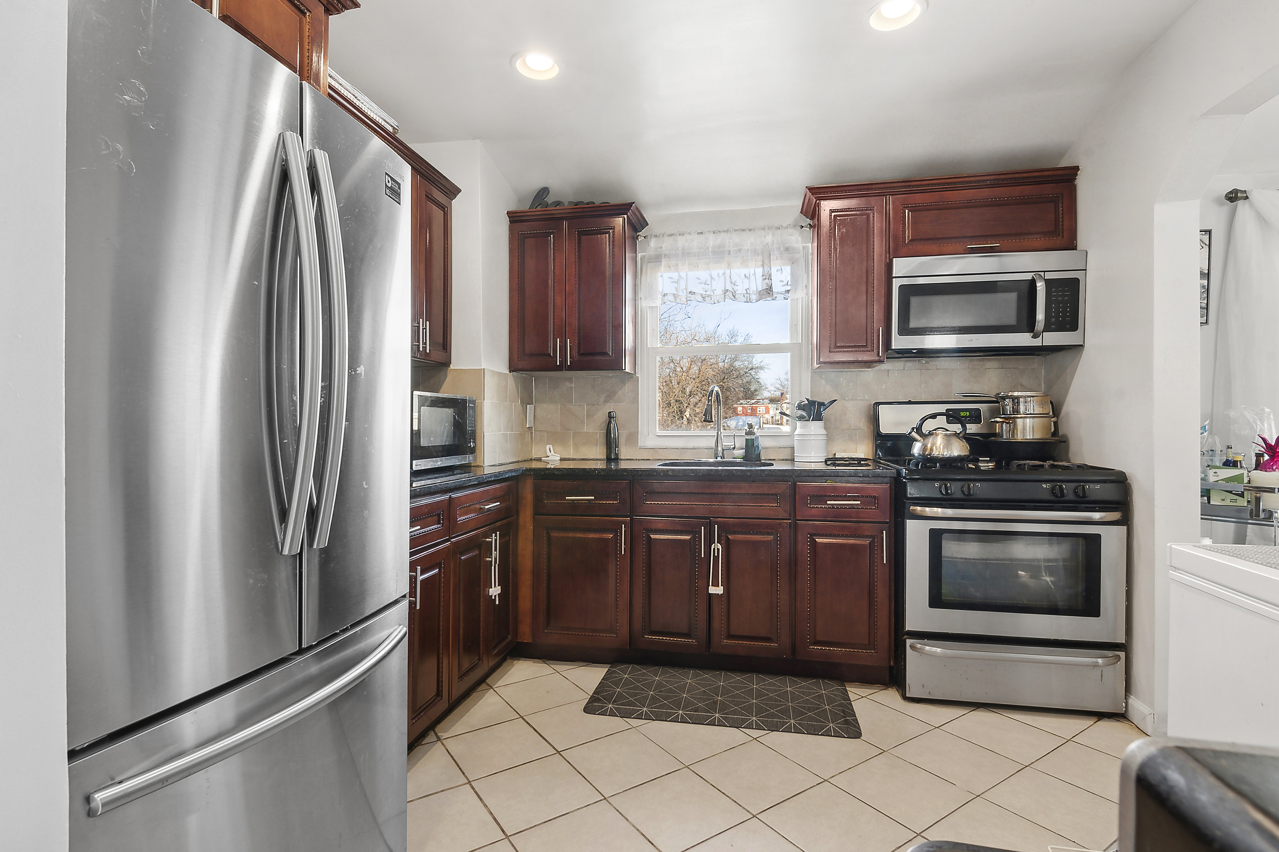 139-14 Springfield Boulevard Queens, NY 11413 - Photo 2 of 7 a kitchen with stainless steel appliances granite countertop a refrigerator stove and sink