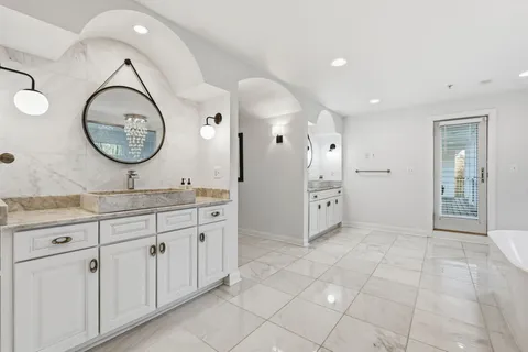 a bathroom with a granite countertop sink a mirror and a shower