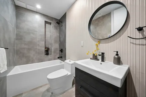 a bathroom with a sink a toilet and a mirror