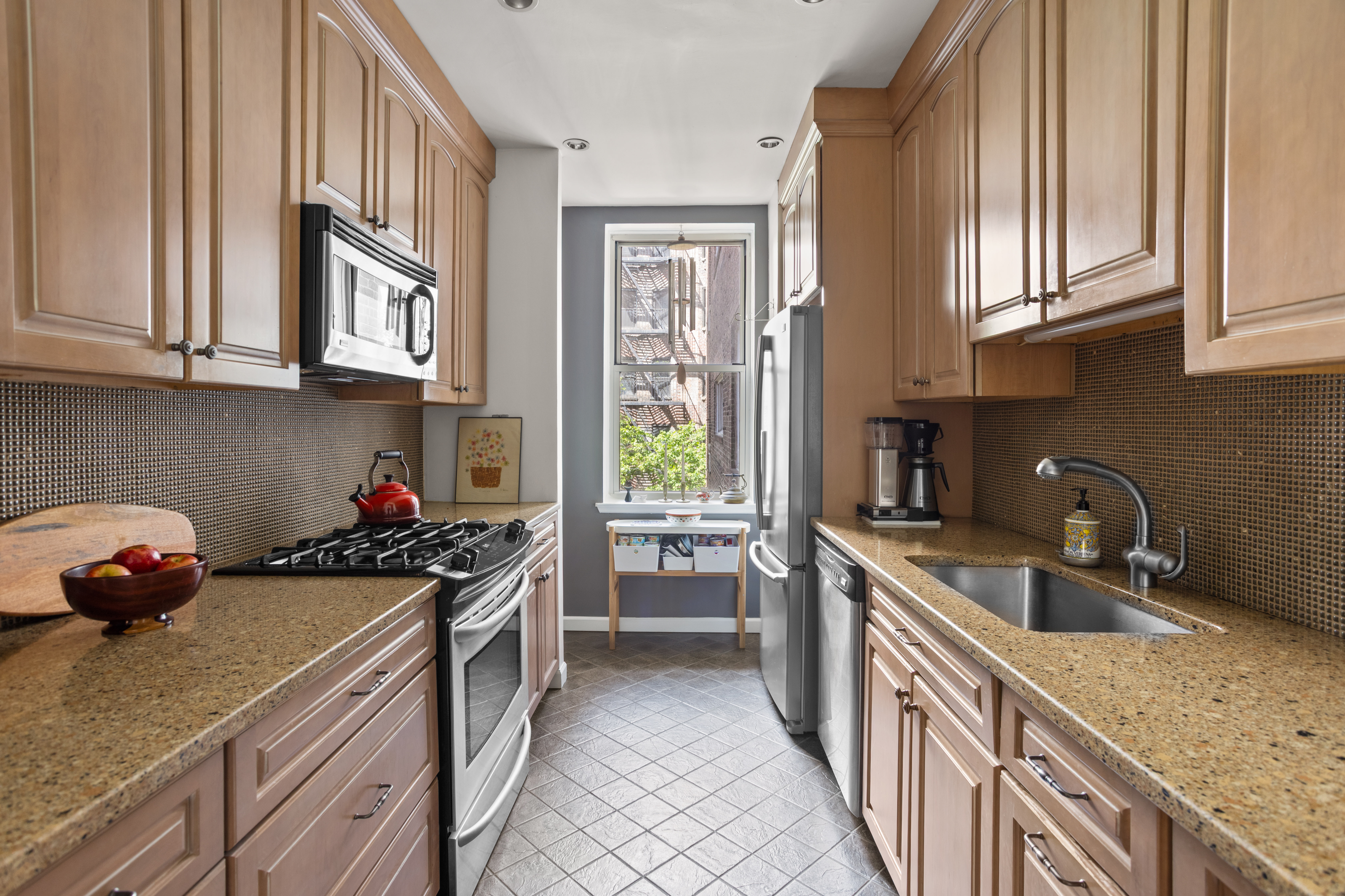 161 East 90th Street, Unit 3B Manhattan, NY 10128 - Photo 3 of 11 a kitchen with stainless steel appliances a sink stove and cabinets