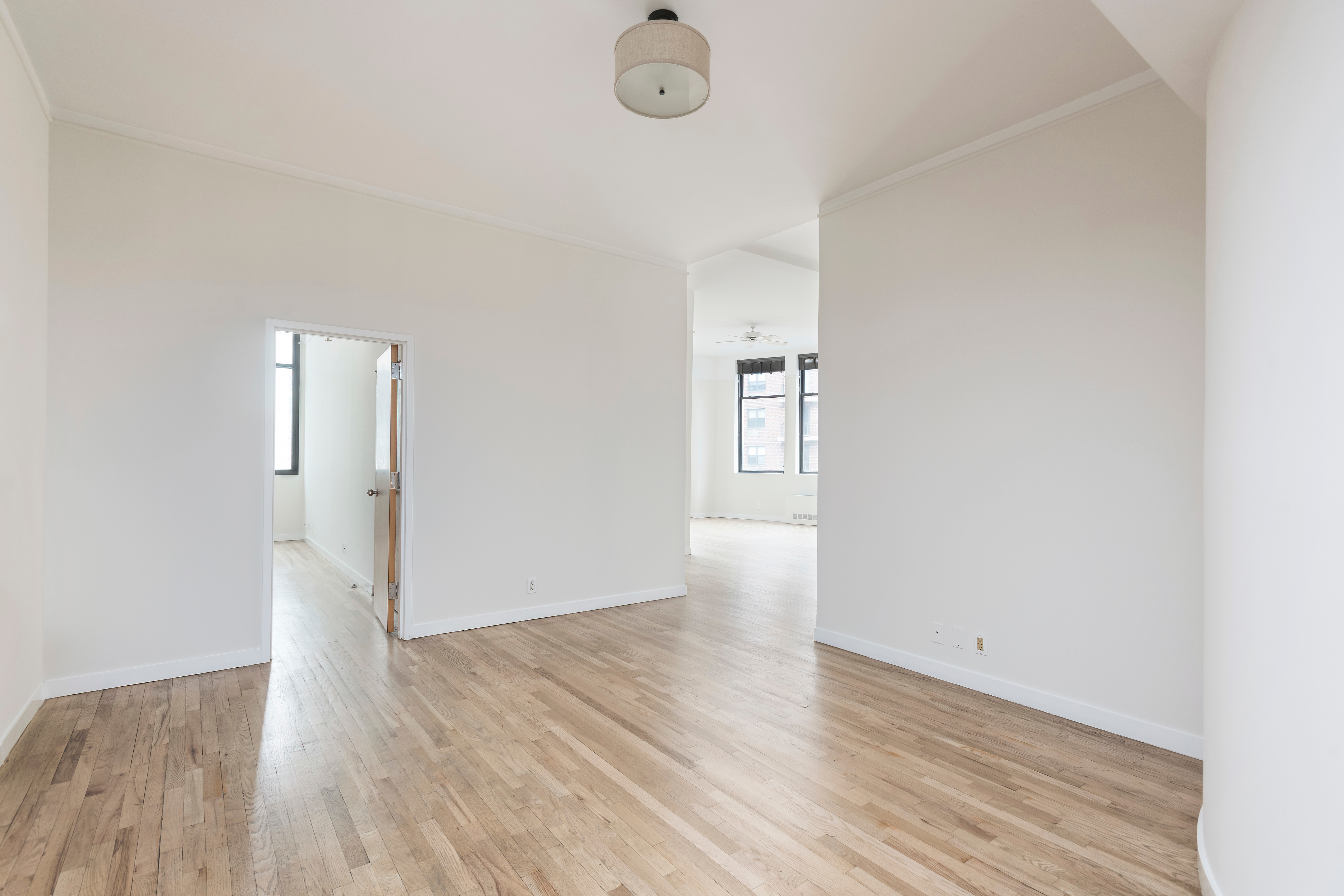 115 4th Avenue, Unit 5C Manhattan, NY 10003 - Photo 4 of 11 an empty room with wooden floor and windows
