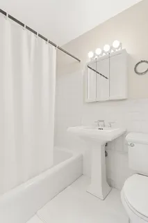 a bathroom with a sink a toilet and shower