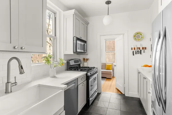 a kitchen with a sink a stove a refrigerator and a window